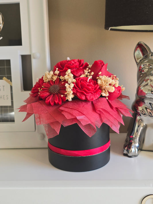 Bouquet de roses rouges moulées en cire de soja parfumée de Grasse, présenté dans une boîte ronde noire avec un ruban rouge. Cadeau original durable pour femme.