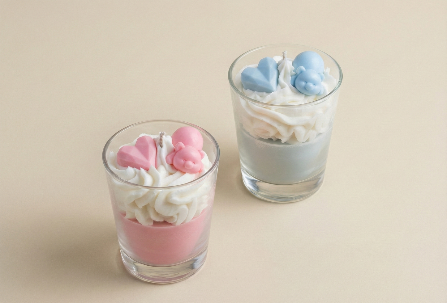Duo de bougies gourmandes chantilly rose et bleue avec oursons et cœurs, photo produit sur fond beige neutre