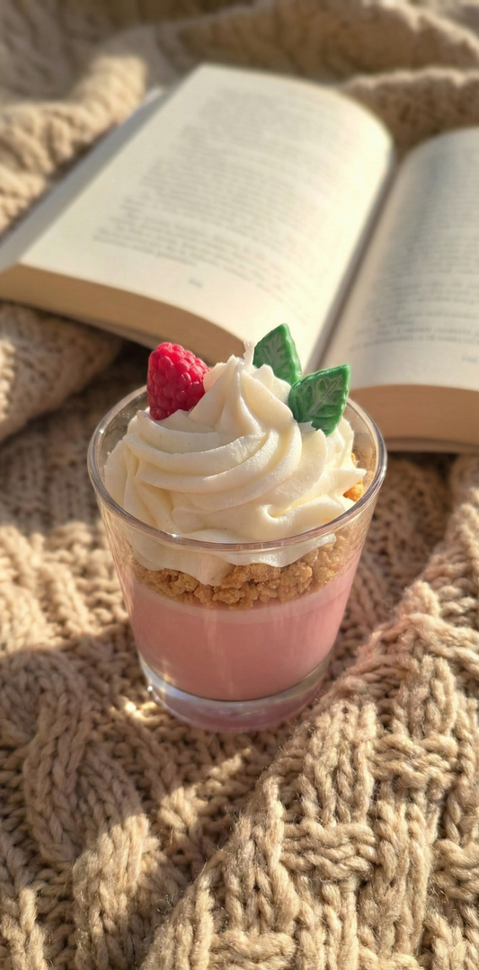 Bougie décorative parfumée sur un plaid en tricot beige épais avec un livre ouvert, idéale pour une ambiance lecture cocooning en hiver.